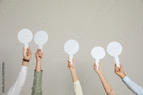 Panel of judges holding blank score signs on beige background, closeup. Space for text