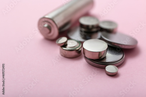Different batteries on pink background, closeup