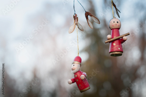  Czerwona świąteczna zawieszka choinkowa na świerkowej gałęzi.