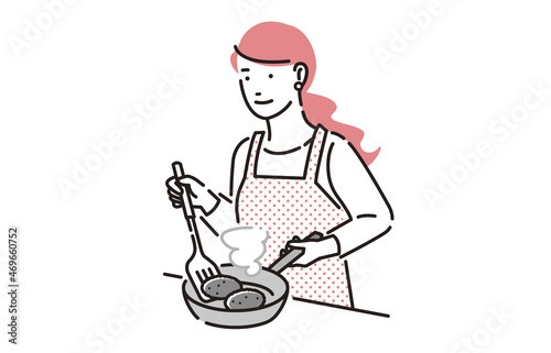 フライパンで料理をする女性