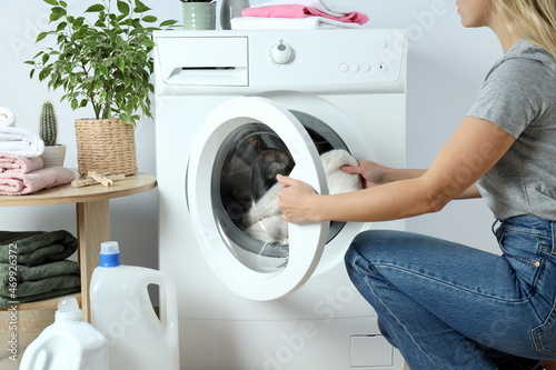 Concept of housework with washing machine and girl on white background