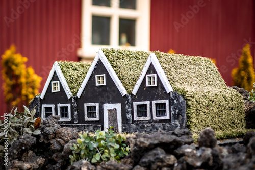Hafnarfjordur, Iceland - September 05, 2021: Three black elf houses. Small hand-made wooden homes for elves as a garden decoration in front of a residential house.