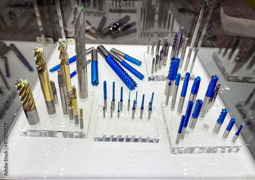 display case with machining tools, drills, milling cutters, reamers of different diameters with multilayer titanium coatings in gold and blue, on methacrylate supports