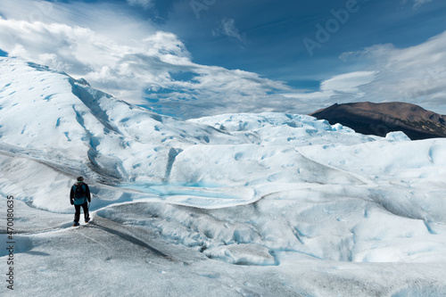 A man walking on the ice formation of the Perito Moreno Glacier
