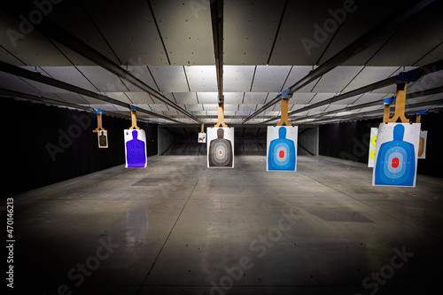 professional Indoor target shooting range looking down range at targets. Assorted targets have bullet holes.