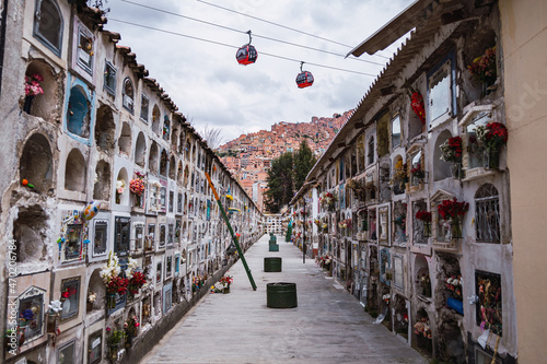 A view of two cable cars gondolas which are a part of the Teleferico system in La Paz Bolivia in South America over the general city cemetery