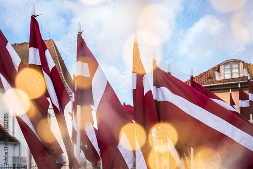 Lots of Latvian red and white flags on the day of proclamation of the Republic of Latvia. Faded yellow lights