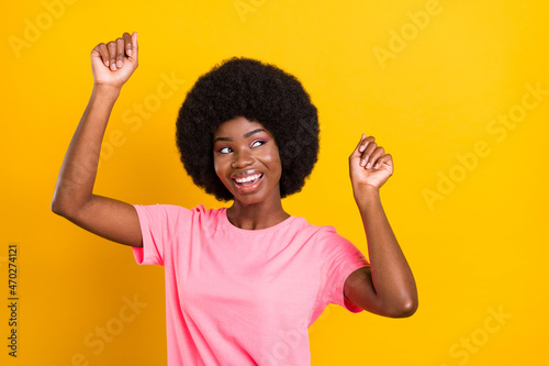 Photo of young excited african girl happy positive smile dance look empty space isolated over yellow color background