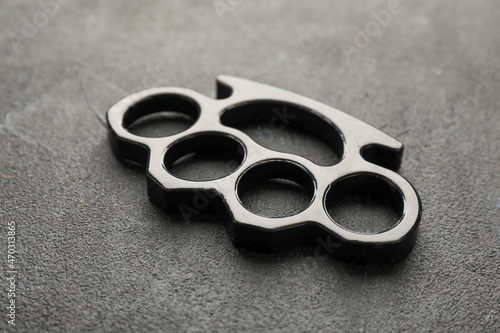 Brass knuckles on black stone background, closeup