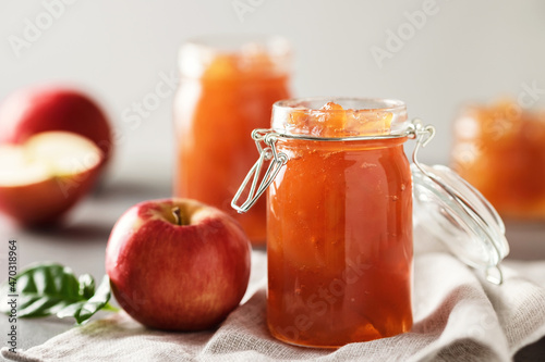 Apple jam in a glass jar. Apple jam on a light background. Delicious natural marmalade.
