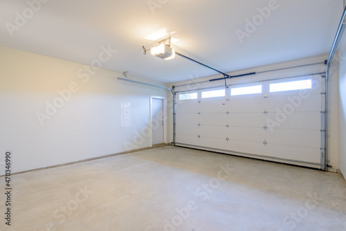 An empty garage with door and windows.