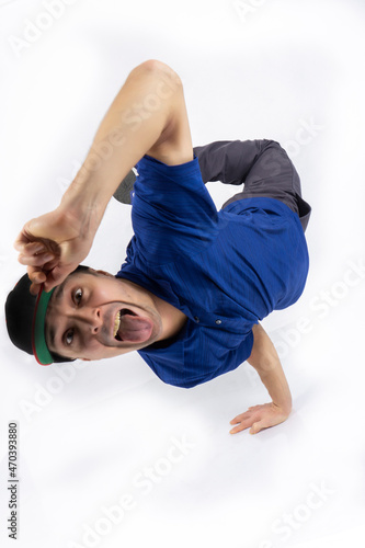 A break dance dancer in a hip-hop dance stand stands on his hands isolated on a white background. Bboy.