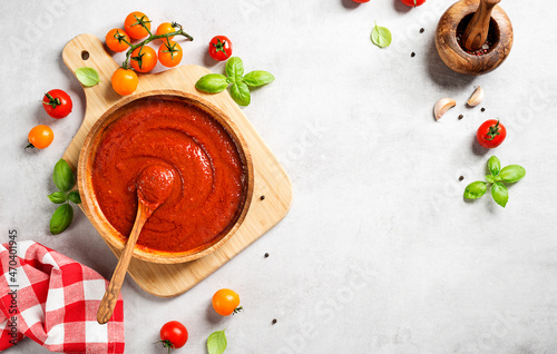 Classic homemade Italian tomato sauce with basil for pasta and pizza. Light gray stone background. top view 