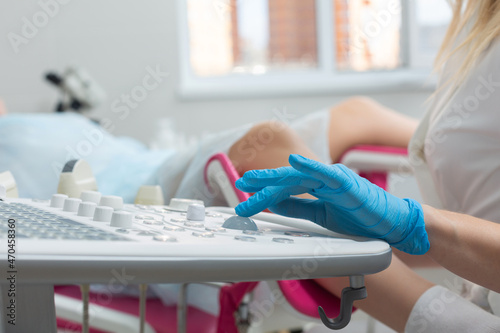 A gynecologist performs an ultrasound diagnostic procedure for a girl lying in a gynecological chair. Pregnancy management, fetal health monitoring