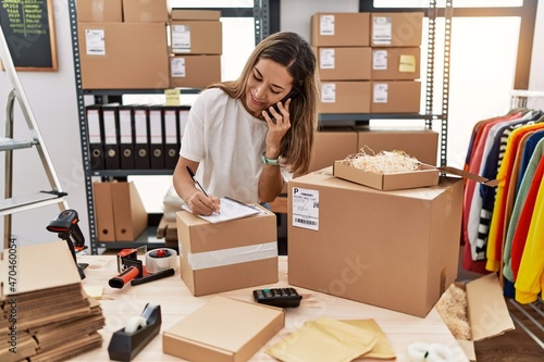 Young hispanic woman talking on the smartphone working at store