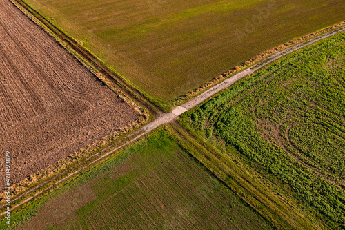 Luftaufnahme zweier Feldwege die inmitten von Feldern im Winter markante Linien eine Kreuzung bilden
