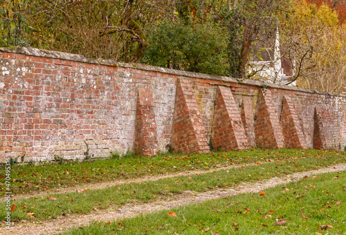several buttress piers supporting a red brick wall of an English Country House in Fittleton, Wiltshire UK