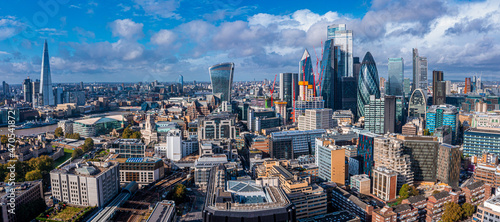 Aerial panoramic scene of the London city financial district with many iconic skyscrapers near river Thames.