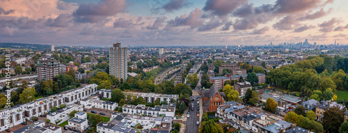 Beautiful aerial view of London with many green parks and city skyscrapers in the foreground.