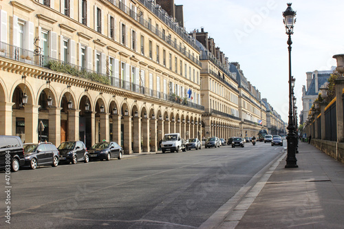 Cozy small streets of Paris. Everyday life. Beige buildings with several floors. Roads with cars, bicycles. French life.