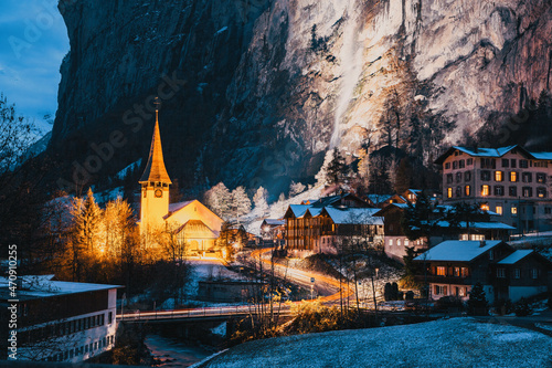 amazing touristic alpine village at night in winter with famous church and Staubbach waterfall Lauterbrunnen Switzerland Europe