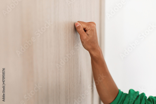 Closeup of woman knocking on the wooden door