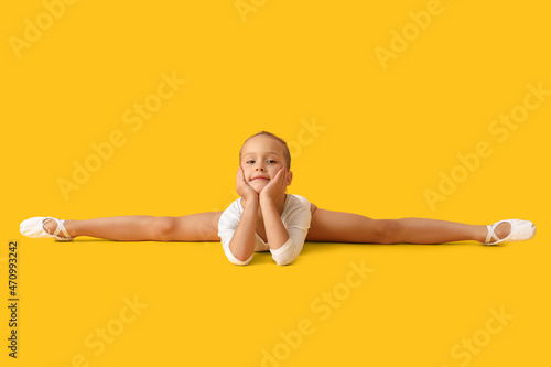 Little girl doing gymnastics on color background