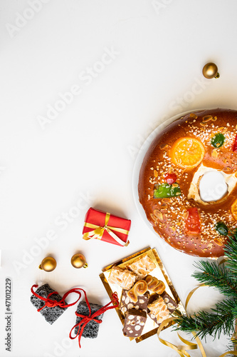  Spanish Christmas concept. Roscon de reyes, Spanish cake , sweet coal , turrones and red gift boxes on white background