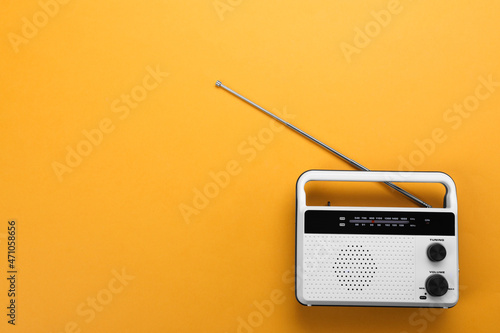 Retro radio receiver on orange background, top view. Space for text