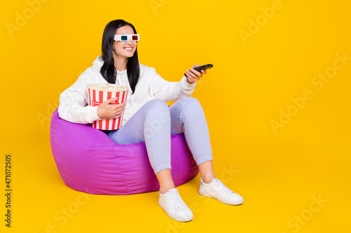 Full body photo of positive lady sit bag chair watch comedy hold pop corn basket isolated over shine color background