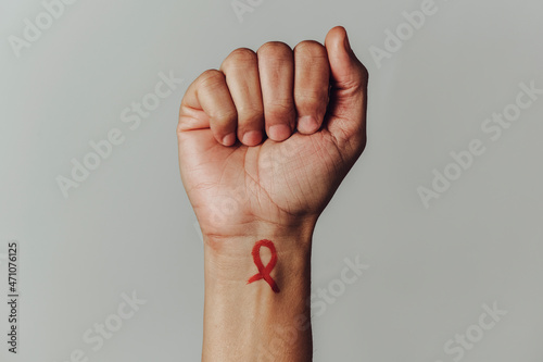 red ribbon for the fight against AIDS in his wrist