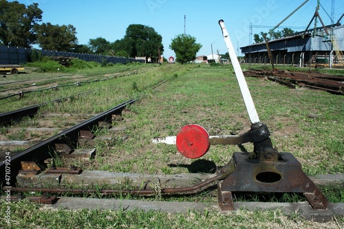 Dispositivo de palanca para cambiar las vías del antiguo ferrocarril con la parte inferior del tren en la estación con cielo azul.