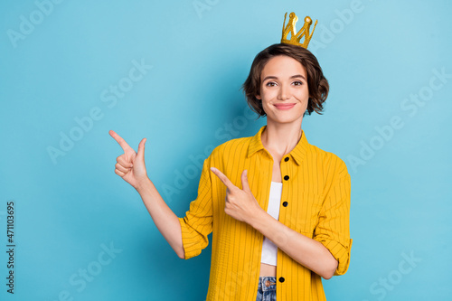 Photo of promoter prom queen lady direct fingers empty space wear crown yellow shirt isolated blue color background