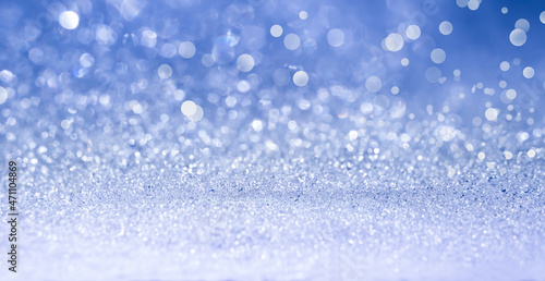 Defocused blue glitter background with copy space. Winter abstract background. Blurred snowy background