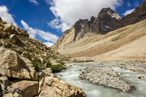 The Zanskar river flows through the high rocky mountains on a trekking route in the Great Himalayan range in Ladakh in north India.