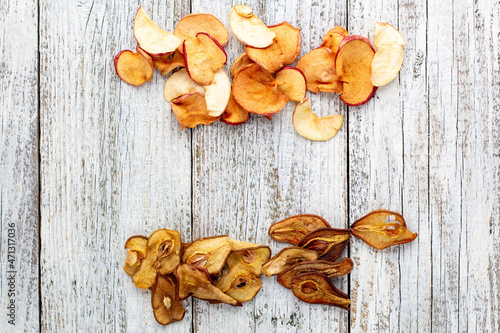 Border of a pile of dried pears and apples in slices on a white wooden background. Dried fruit chips. Healthy food