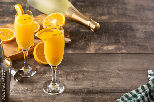 Orange mimosa cocktail on wooden table. Copy space