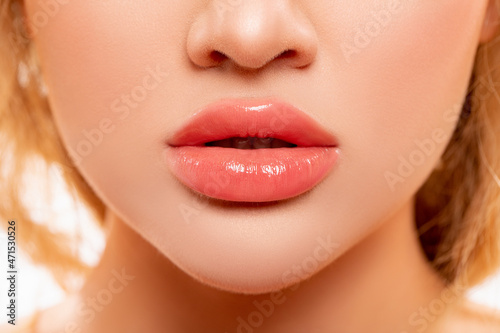 Sexy Lips. Part of Face, Young Woman close up. Perfect plump Lips bodily Lipstick. Peach Color of Lipstick on Large Lips. Perfect Makeup. Beautiful Lips Close-up. Makeup. Lip shiny Lipstick. 