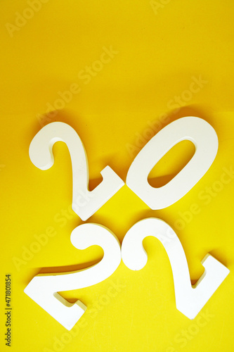 Flat lay Happy New year 2022 , 2022 number wood object on yellow background and copy space - yellow color new year celebrate and business resource concept - marketing resource design template 