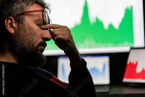 Depressed businessman in front of computer with graph of unsuccessful business on the screen. High quality photo.