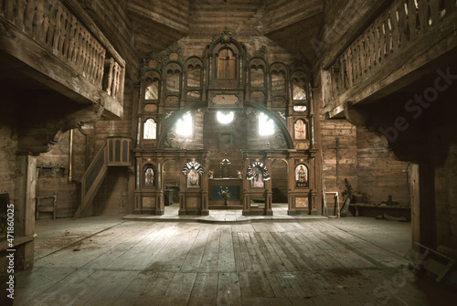Interior of an old abandoned church somewhere in Eastern Europe. Wooden altar and iconostasis in melancholic ruination. 