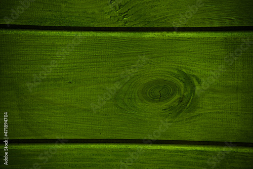 Deska drewniana z sękiem - tekstura , tło . Ściana zielona , drewno . Wooden board with a knot - texture, background. Green wall, wood. 