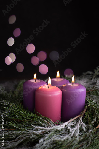 Three Christmas purple and one pink advent candle.