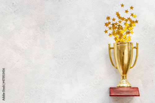 Victory concept with winner golden trophy cup and shiny stars