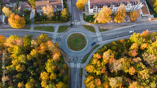 Top view of roundabout street with cars in a German city with autumn trees
