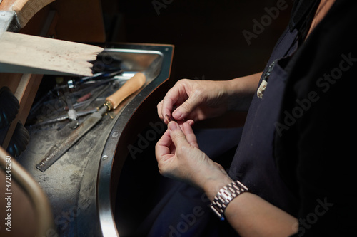 close up of the hands of an artisan woman adjusting handmade jewel