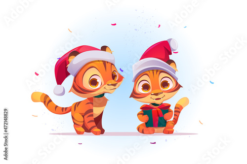 Cute New Year tiger cartoon character in Santa Claus hat with gift box in paws and confetti falling. Wild funny kitten animal cub with present, kawaii 2022 chinese zodiac symbol, Vector illustration