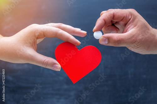 The hand holds out a white tablet in the symbol of the heart