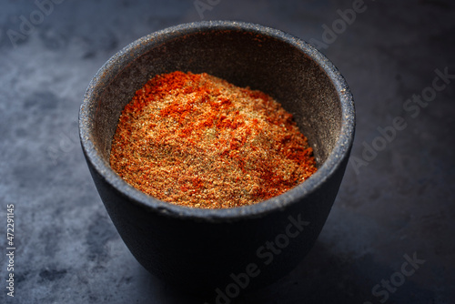 Traditional fine grinded rub for barbecue pulled beef and pork offered as close-up in a rustic bowl with copy space