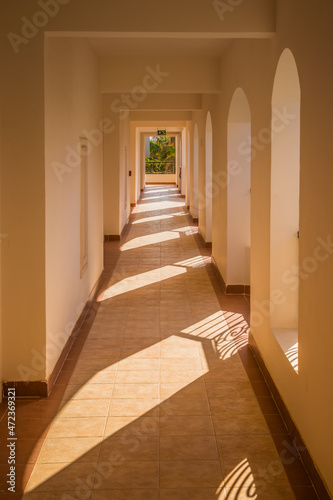 EGYPT. LUXOR - 10.10.2021. Arches in arabic style. The corridor and arches of the white building are illuminated by the sun. Architectural symmetry. Acri one by one